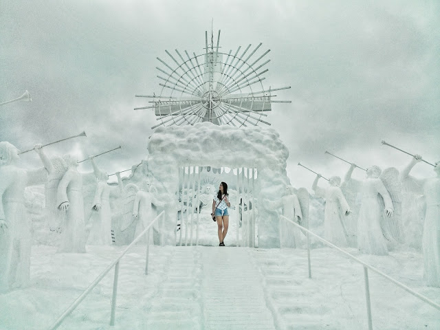 a girl standing at the top of a staircase of an all-white heaven-like structure