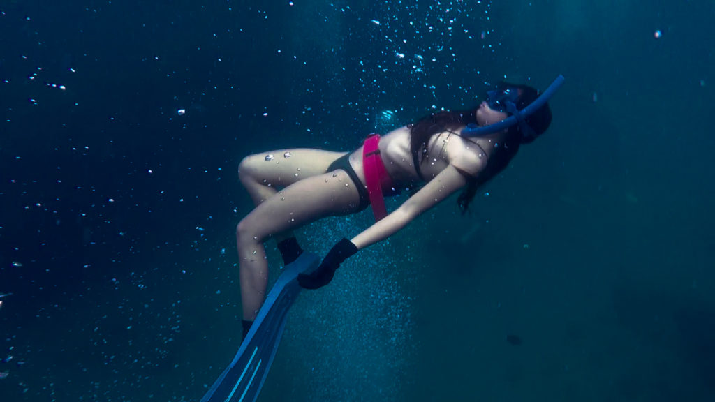 A freediver seemingly weightless underwater