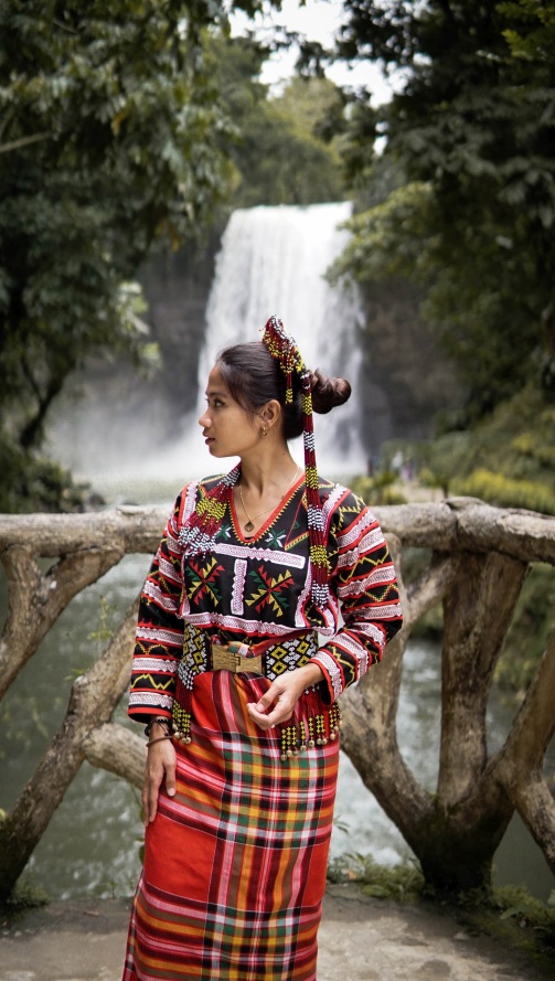 A woman in T'boli costume in front of Hikong Alu, one of the Seven Waterfalls in Lake Sebu